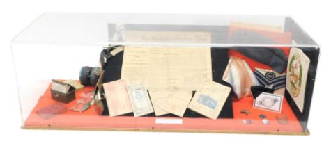 A display case containing various World War II memorabilia, to include newspapers, ephemera, RAF cap