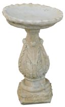 A reconstituted stone birdbath, on pedestal vine stem, with circular piecrust top on a square base,