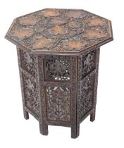An Indian hardwood folding occasional table, the octagonal top and sides decorated with grapes and l