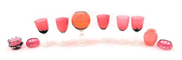 A group of cranberry glasswares, comprising five wine glasses, a domed and stemmed glass, three pin