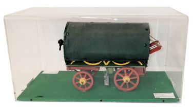 A scale model of a covered gypsy style wagon, polychrome decorated with grey cover, in perspex case,