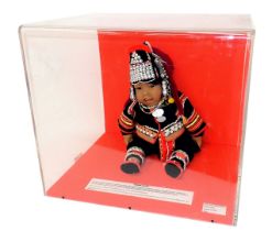 A costume doll model of a Northern Thai baby, wearing traditional costume of the Akha Hill Tribe in