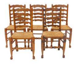 A set of five Lancashire type ladder back dining chairs, each with a rush seat on turned tapering le