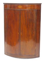 An early 19thC mahogany and chequer banded hanging corner cabinet, the frieze inlaid with a shell, a
