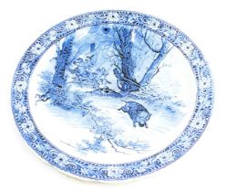 A Delft style charger, with transfer printed decoration of wart hog and hunting warriors, 39cm diame