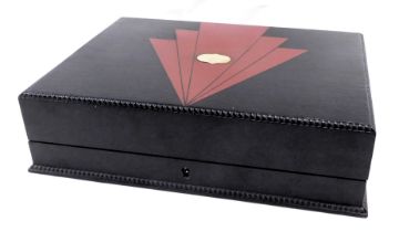 A rectangular storage box, painted in black with applied art deco red detailing, and central plaque