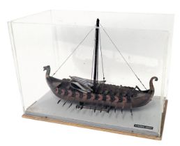 A scale model of a Viking ship, with single mast, polychrome decorated, in perspex case, 55cm wide.