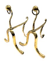 A pair of Victorian brass fire dogs, with a moulded front and swing handle, 36cm high, 26cm deep.