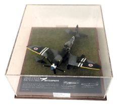 A scale model of a RAF Spitfire, mounted on stylised grass with plaque, 1-32ND, in perspex and woode