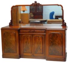 A late Victorian mirror back sideboard, the shaped mirror plate with central carved scrolling boss,