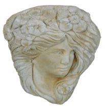 A reconstituted stone lady's face wall mounted plaque, in the Art Nouveau style, 31cm high.