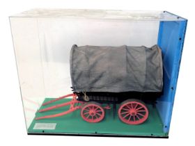 A scale model of an 18thC American stage wagon, polychrome decorated with canvas cover, in glazed pe