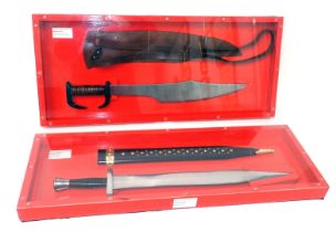 A replica Greek Spartan sword with scabbard, and a Greek sword, both in perspex and red painted wood