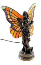 A Tiffany style table lamp, formed as a female with butterfly wings, on orange and yellow glass grou