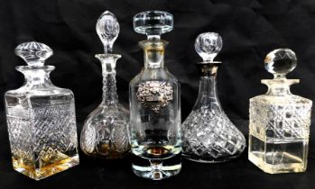 Five cut glass decanters, one with a silver collar.