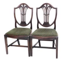 A pair of George III mahogany dining chairs, each with a pierced splay carved with fleur de lys, dro