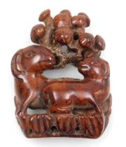 A 20thC Japanese style hardwood netsuke, carved as a ewe and ram beneath a tree, 4cm wide.