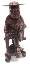 A late 19thC Qing dynasty hardwood carving of a priest, modelled standing, holding a string of beads