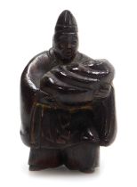 A contemporary Japanese style hardwood netsuke, of a man holding a baby in a swaddling blanket, 4.5c