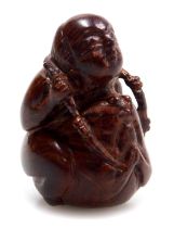 A contemporary Japanese style hardwood netsuke, carved as a boy seated upon a toad, 3.5cm high.