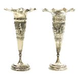 A pair of early 20thC Thai bud vases, of trumpet form, repousse decorated with a central band depict