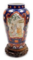 A Meiji period Imari porcelain vase, of shouldered, tapering form, decorated with reserves of sages,