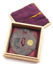 A Muromachi period iron tsuba, Saotome school, of mokko shape, decorated with a circular gold mon de