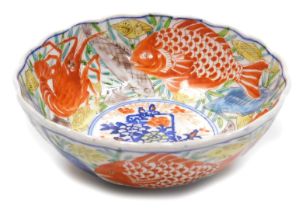 A Meiji period Japanese Imari bowl, of fluted form, decorated with a basket of flowers, in a border