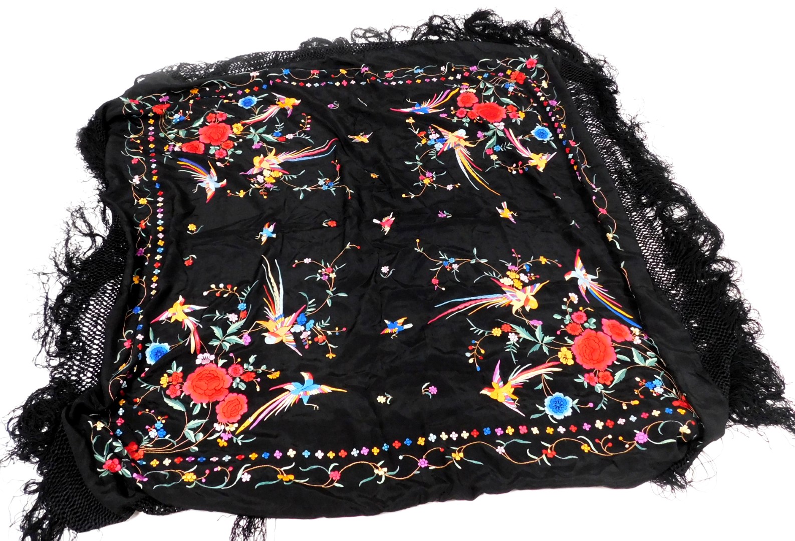 A 20thC Chinese black silk shawl, embroidered with exotic birds, and flowers, with a tassel fringe,