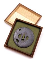 An Edo period iron tsuba, of circular form, with pierced decoration of a flower, and interlock