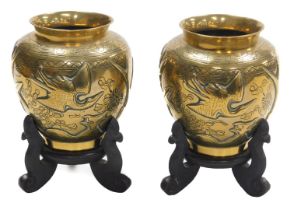 A pair of early 20thC Chinese heavy brass vases, embossed with a deer, bamboo, trees and a crane, th