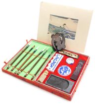 A 20thC Zhengda calligraphy set, boxed, together with a wooden pen stand, and a print, after Katsuch