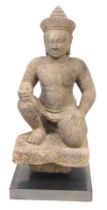 A Khmer sandstone figure of Varuna, in a seated door keeper pose as guardian of the west, possibly 1