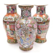 A pair of Cantonese famille rose porcelain vases, of baluster form, decorated with reserves of inter