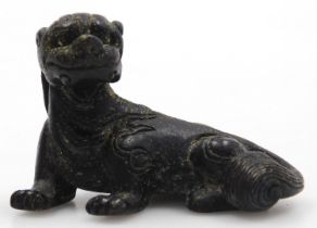 A 19thC Chinese bronze scroll weight modelled as a recumbent dog of fo, 5cm long.