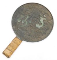 A Meiji period Kagami bronze hand mirror, the reverse embossed with a pine tree and cranes, and two