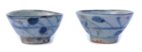 A pair of Ming dynasty blue and white porcelain cups, with naive foliate decoration, 5cm wide.