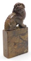 A 20thC Chinese soapstone carving of a Foo dog, modelled seated on a rectangular plinth, 13cm high.