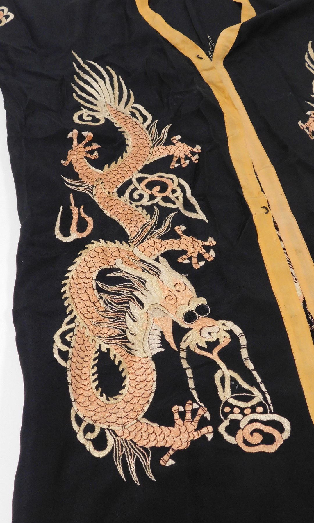 An early 20thC Chinese black silk short surcoat, embroidered with dragons in pink and white, with pe - Image 2 of 5