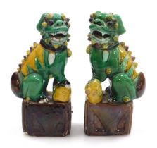 A pair of 19thC Qing dynasty porcelain Sancai style Foo dogs, with a green and yellow glaze, modelle