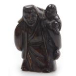 A contemporary Japanese style hardwood netsuke, carved as an elderly man with a boy upon his shoulde