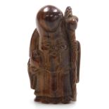 A contemporary Japanese style hardwood netsuke of Fukurokuju, modelled standing holding a peach in o