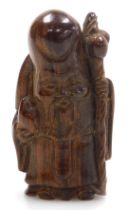 A contemporary Japanese style hardwood netsuke of Fukurokuju, modelled standing holding a peach in o