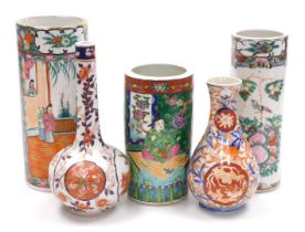 A pair of Cantonese famille rose porcelain cylindrical vases, decorated with figures in an interior,