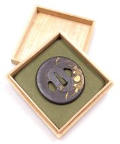 An Edo period iron tsuba, Kaga School, of circular form, decorated in gold with chrysanthemum, signe