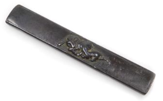 An Edo period kozuka knife handle, decorated in relief with a buffalo, 9.5cm wide.