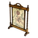 An early 20thC oak fire screen, with a 16thC style rectangular wool work panel, decorated with styli