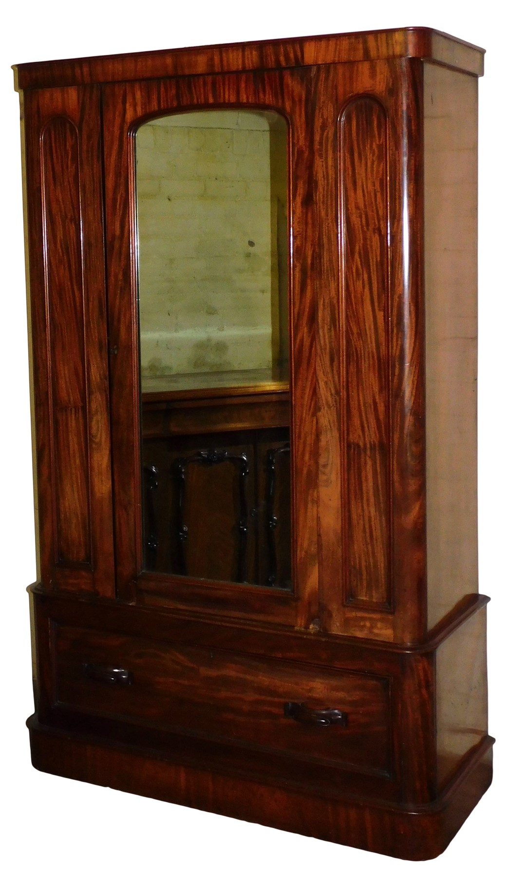 A Victorian mahogany double wardrobe, with a central mirror inset door, opening to reveal a hanging