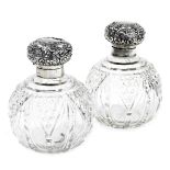 A pair of Edwardian cut glass and silver mounted scent bottles, the hinged lids embossed with shells