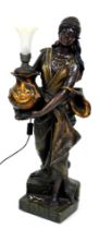 A late 19thC figural plaster torchere, of an exotic peasant woman, holding an oriental vase, raised